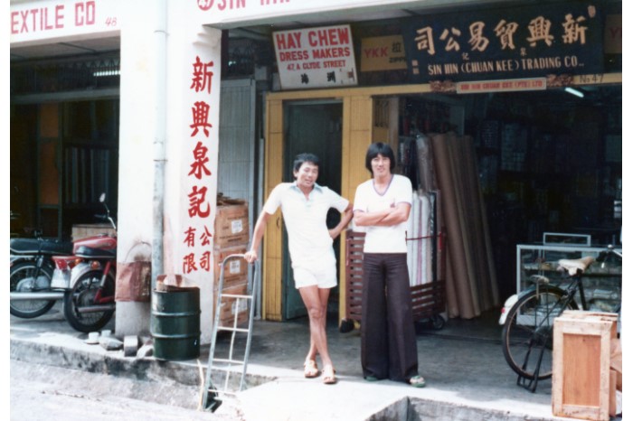 Gambar anak lelaki pengasas, Ng Cheow Poh (kiri) berdiri di hadapan Sin Hin Chuan Kee di Clyde Street.